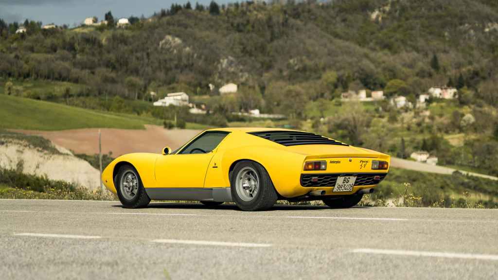 Una Lamborghini Miura SV gialla vista di profilo su una strada di campagna