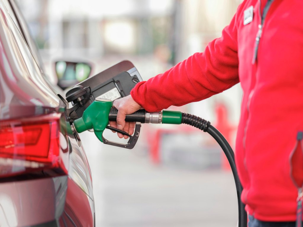 Pistola del distributore inserita nel serbatoio di un'auto moderna